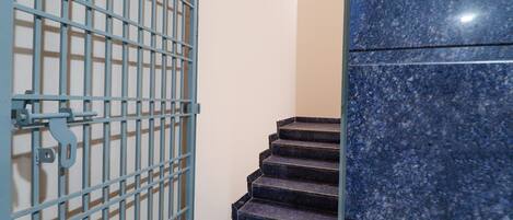 A set of dark granite stairs with a sign indicating to use the stairs.