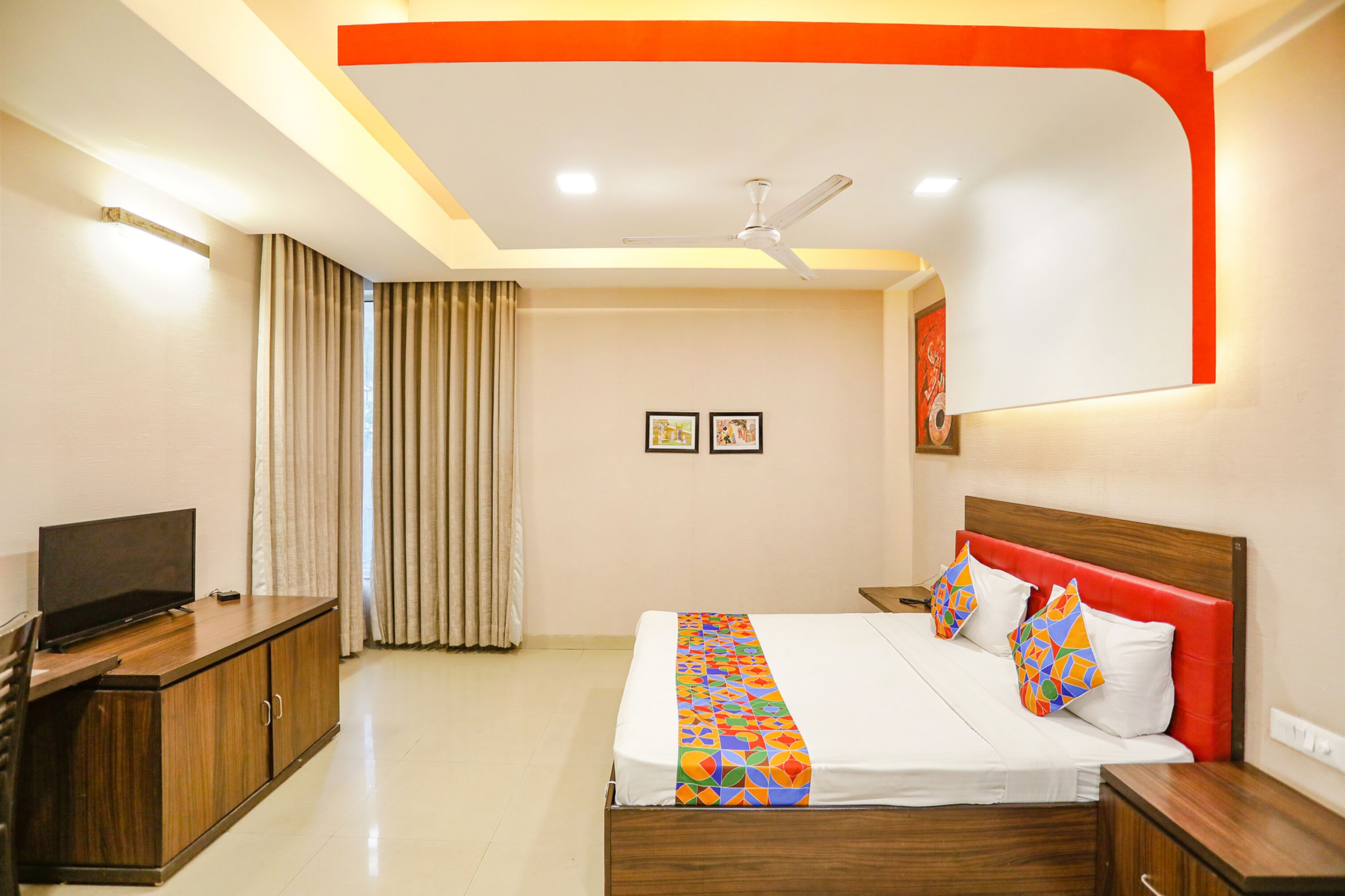 A hotel room with a bed, a TV, a desk, and a wardrobe.