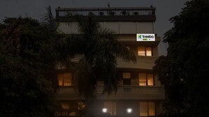 A multi-story building with balconies and windows, surrounded by dense foliage. - Itsy Hotels NV, Sushant Lok (Gurugram)