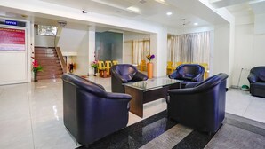 A modern lobby with a reception desk, seating area, and a staircase leading to an upper floor. - Fabhotel Happy Homely Stay (Pune)