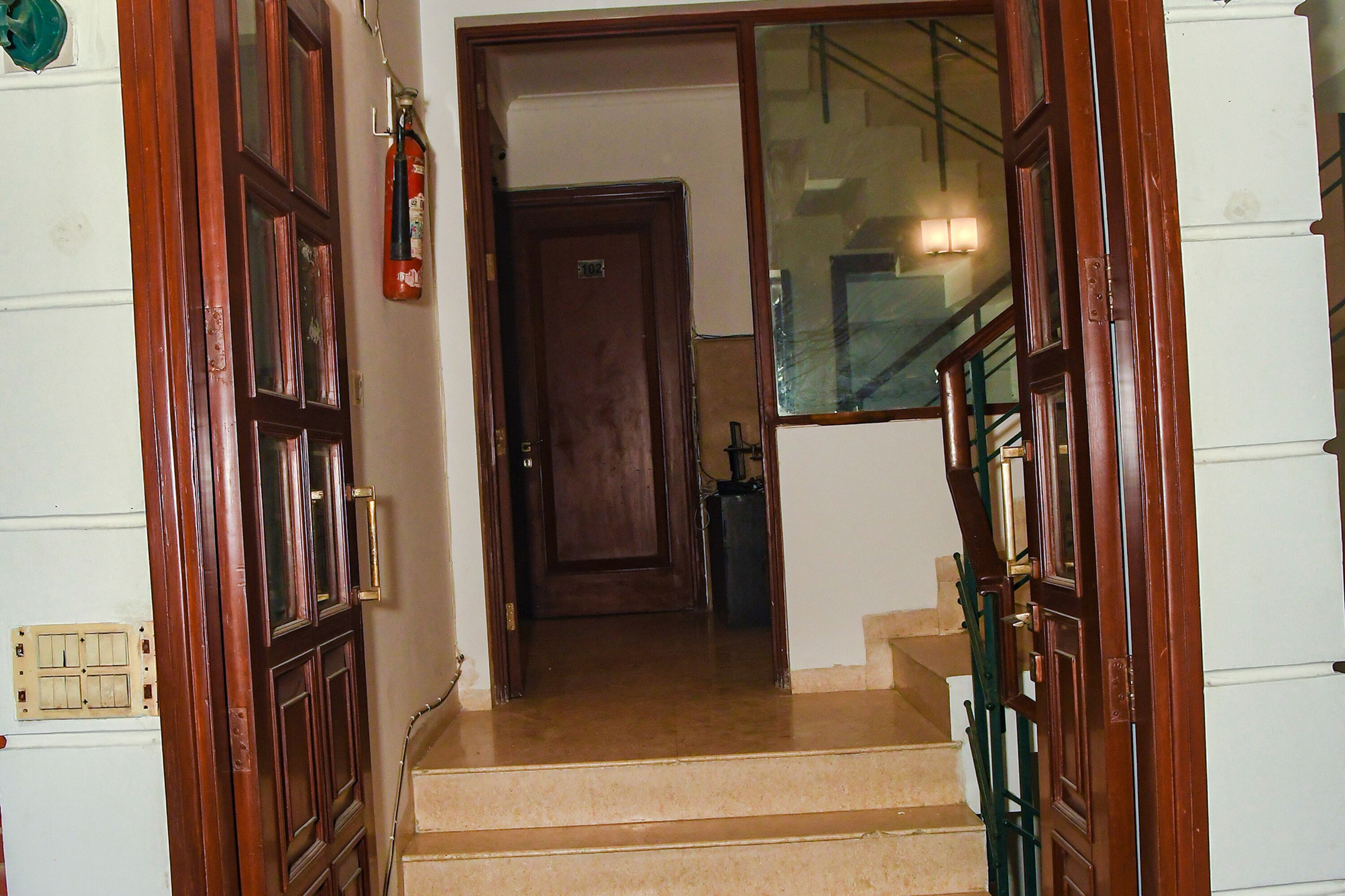 A staircase with wooden doors and a fire extinguisher on the wall.