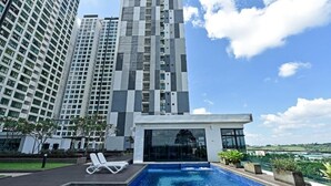 A modern building with a rooftop pool area, including lounge chairs and a glass-enclosed structure. - D'Summit Residences by YML Home B1 (Johor Bahru)