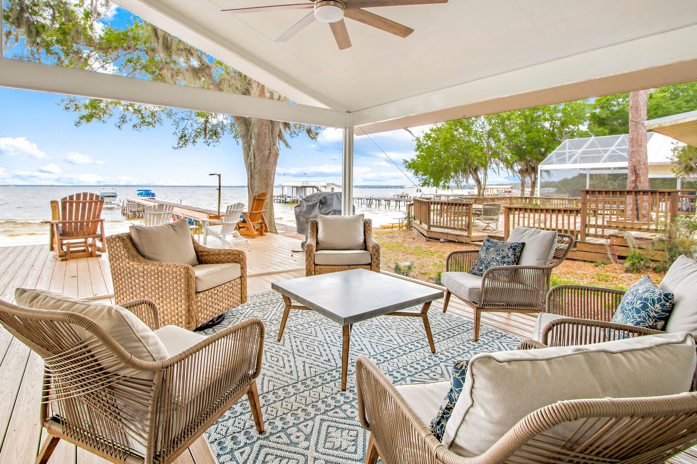 Un espace extérieur aménagé, abrité et doté de mobilier en osier, d’une table et offrant une vue sur la plage et l’océan.