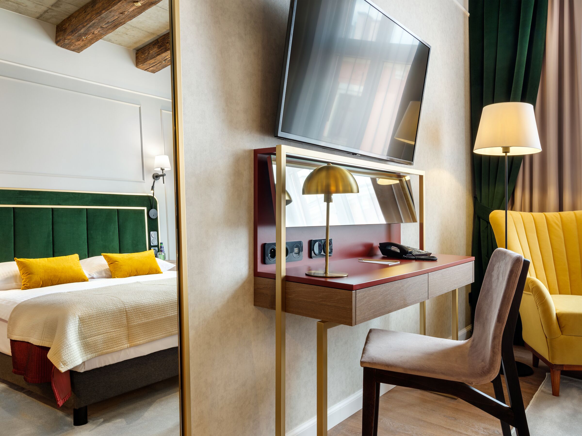 Une chambre d’hôtel comprenant un lit, un bureau avec une lampe, une chaise, un téléviseur et un téléphone.