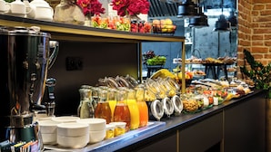 Ein reichhaltiges Buffet mit verschiedenen Speisen und Getränken, darunter Obst, Getreideprodukte und Milchprodukte.