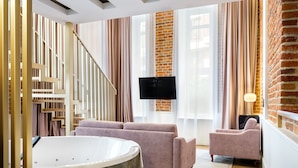 Ein modernes Wohnzimmer mit einer großen Badewanne, einer Treppe und einer Ziegelwand.