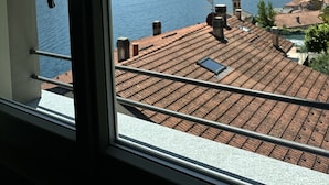 A view from a window overlooking a lake with mountains in the background. - Villa Clementina Boutique Hotel (Colonno)