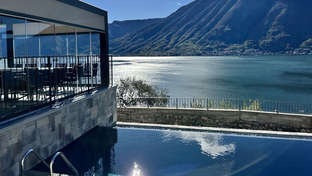 A modern building with a pool and a view of a lake and mountains. - Villa Clementina Boutique Hotel (Colonno)