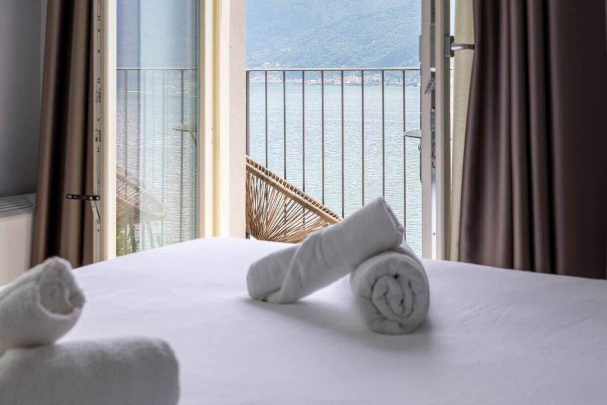 Ein Hotelzimmer mit Bett, Meerblick und Balkon mit Stuhl.