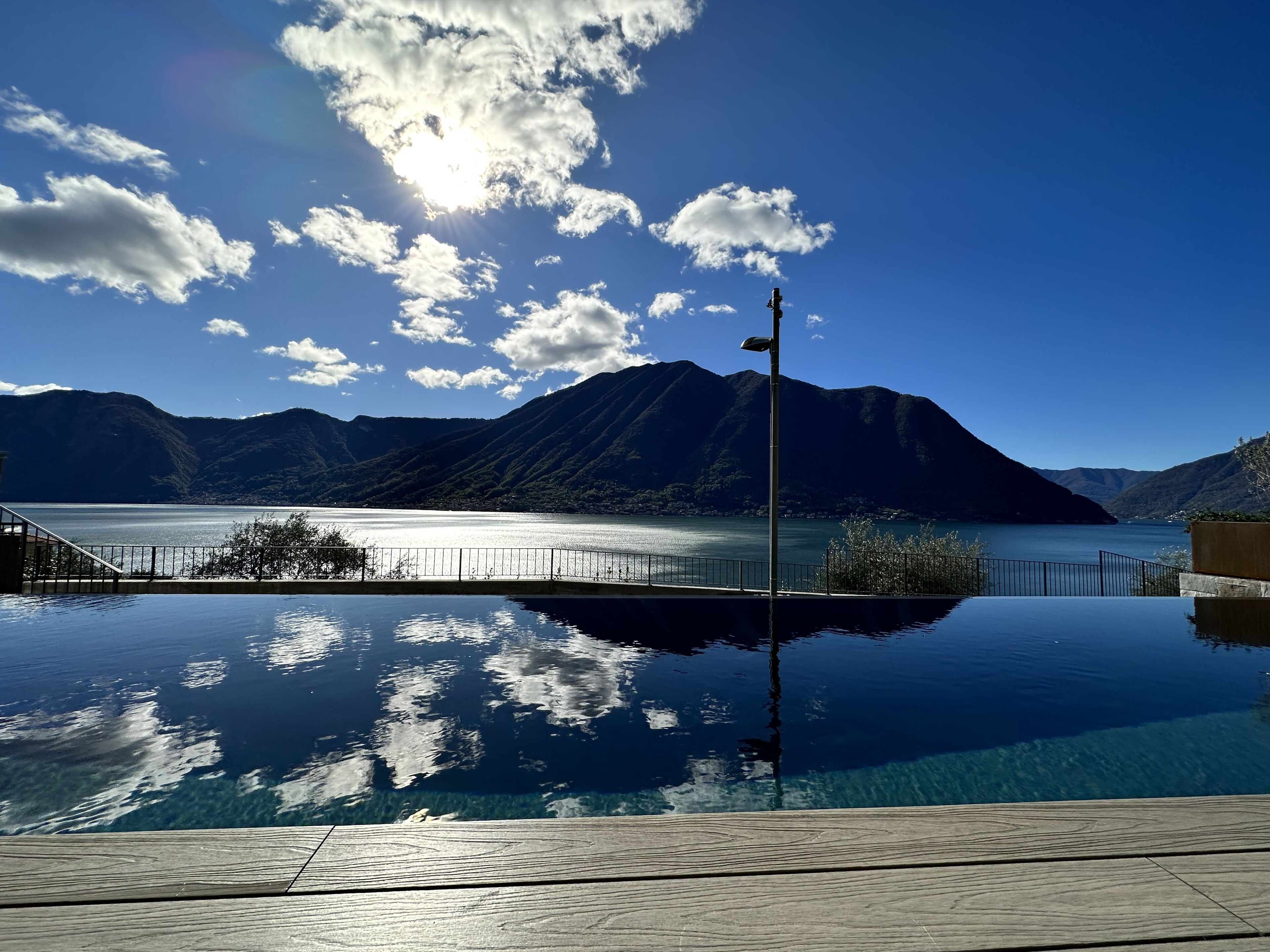 A clear view of a mountain lake with a wooden deck in the foreground.