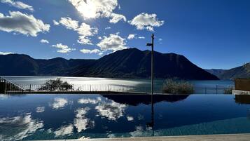 A clear view of a mountain lake with a wooden deck in the foreground.