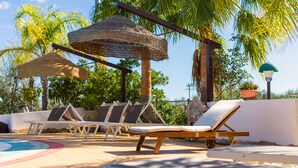 A poolside area with lounge chairs and a shaded area. - Residence Villantica (Vieste)