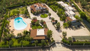 An aerial view of a resort with a swimming pool, multiple villas, and landscaped gardens. - Residence Villantica (Vieste)