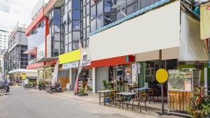 A street with shops, outdoor seating, and parked motorcycles. - Hotel O Wr House Syariah BatamNearEast Coast Park (Batam)