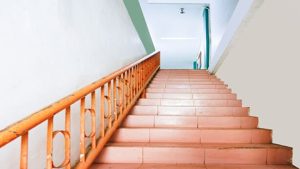 A staircase with orange metal railings and terracotta steps leading to a door. - Hotel O Wr House Syariah BatamNearEast Coast Park (Batam)