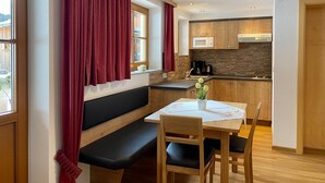 A compact kitchen with wooden cabinets, a microwave, and a coffee maker. - Ihr Zuhause im Urlaub - Familiär und Komfortabel (Niederthai)