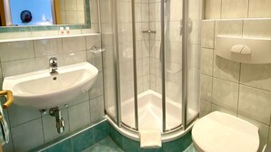 A bathroom with a glass-enclosed shower, a sink, and a toilet. - Ihr Zuhause im Urlaub - Familiär und Komfortabel (Niederthai)