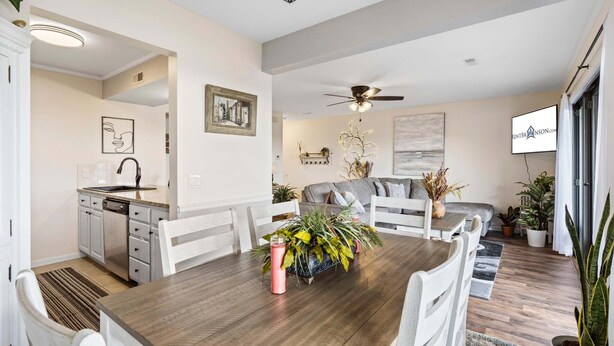 A modern kitchen with white cabinets, a dining table with chairs, and a ceiling fan. - Modern Luxury Condo with Private Deck, Amazing Views, Near SDC with Free Tickets (Branson)