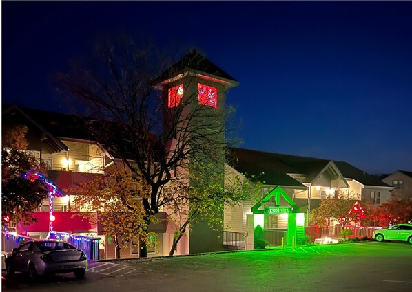 Stunning house with a prominent tower-like structure and a welcoming green-lit entrance.