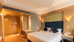 A modern hotel room with a large bed, bedside tables, a wardrobe, and built-in lighting. - Effotel By Sayaji Bhopal (Bhopal)