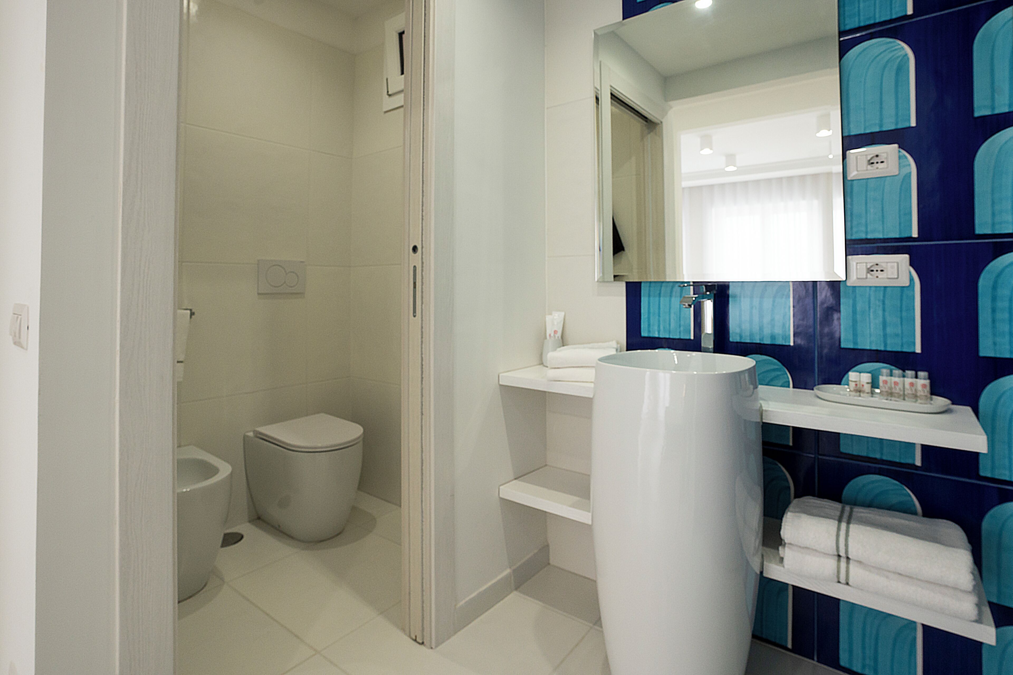 Un baño con inodoro, lavabo y espejo.