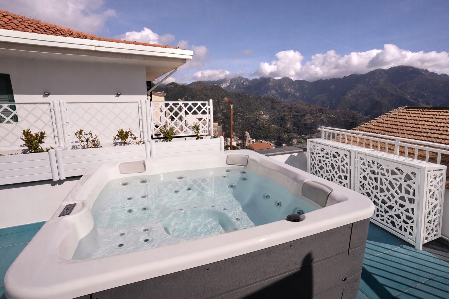 A hot tub on a rooftop with a mountain view.