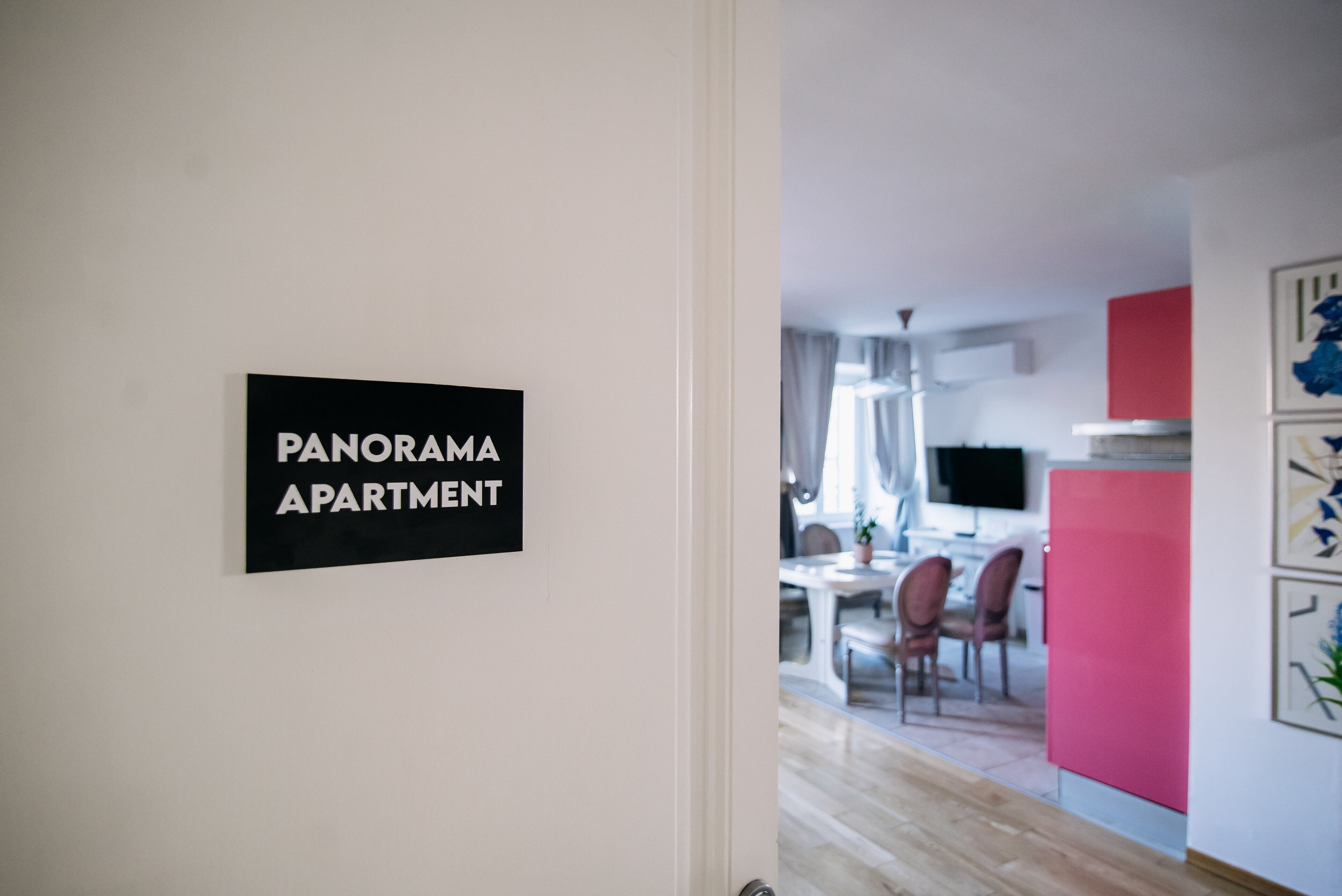 Un letrero con la inscripción 'PANORAMA APARTMENT' en una pared blanca.