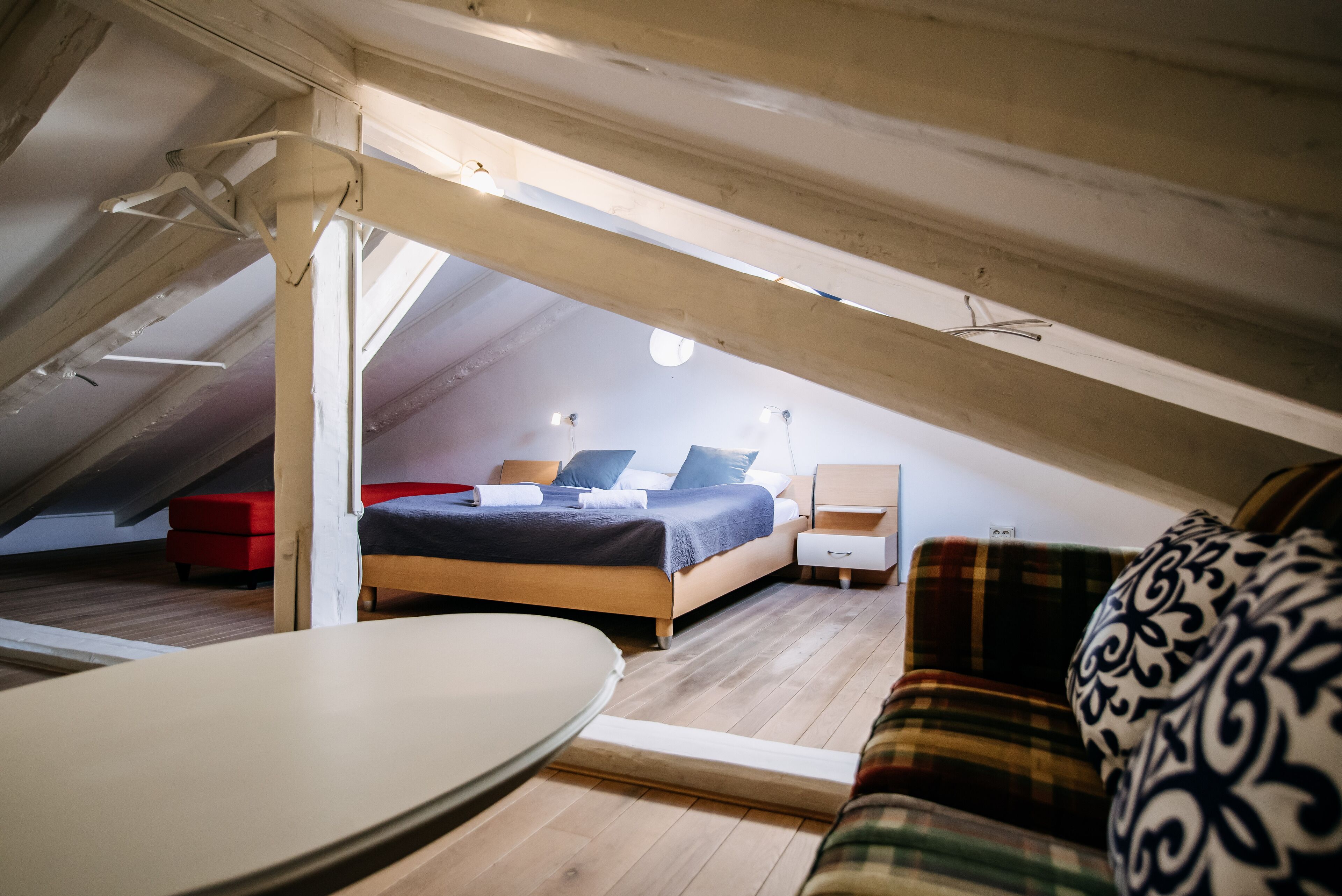 Ein Schlafzimmer im Dachgeschoss mit Bett, Nachttisch und einem roten Sessel.