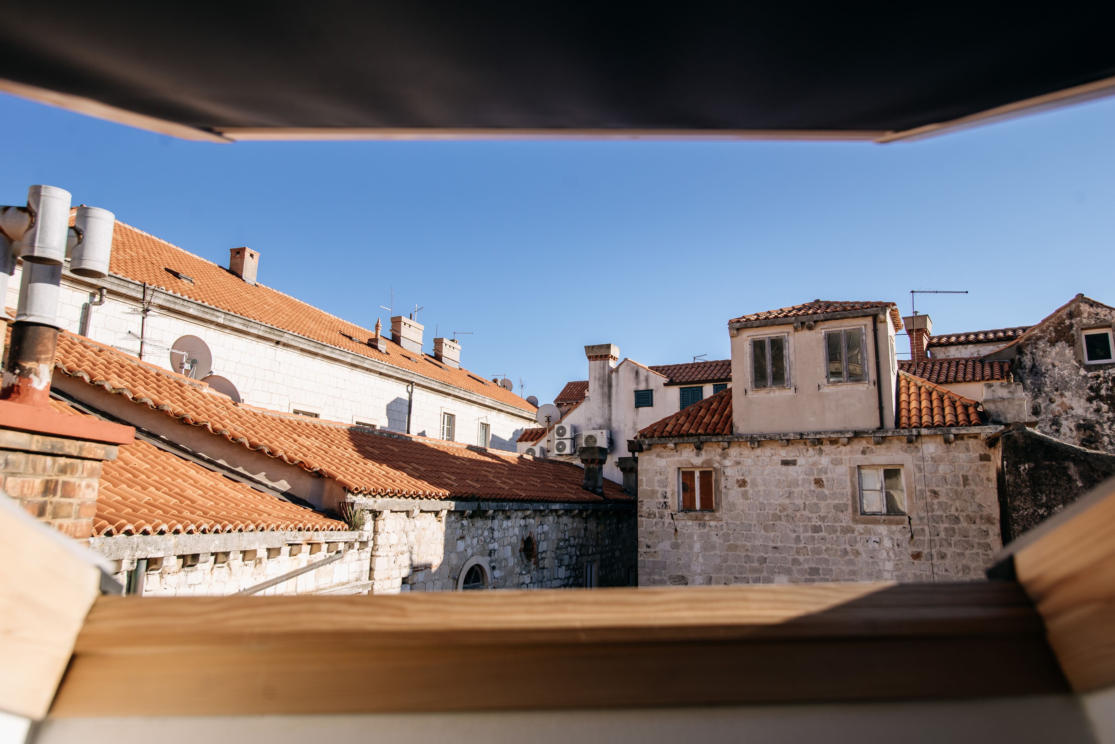 A view of a historic town with traditional architecture, including stone buildings and tiled roofs.