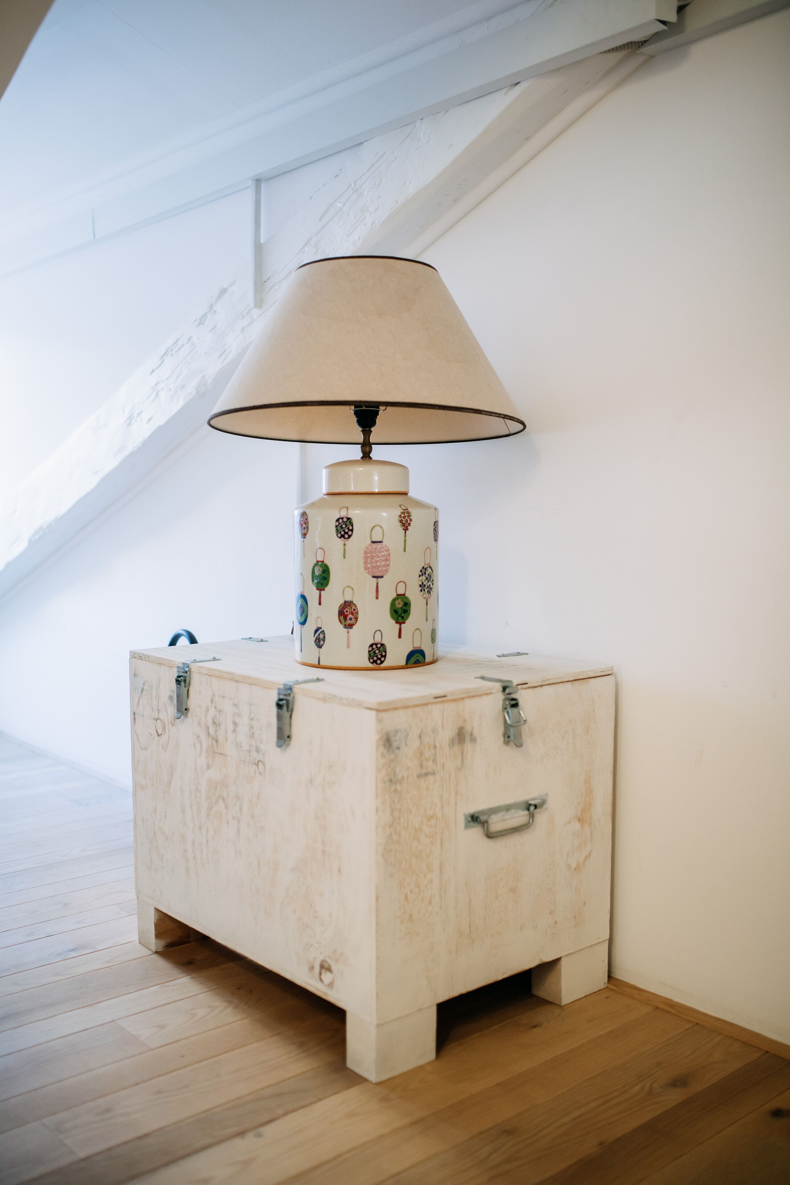 Ein Nachttisch aus Holz mit einer Lampe, einer Schublade und einem Metallgriff.