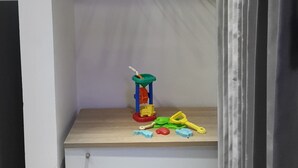 Une pièce avec une armoire blanche, une étagère en bois et un portant à vêtements.