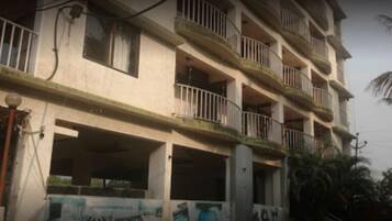 Un edificio de varios pisos con balcones, algunos con barandillas.