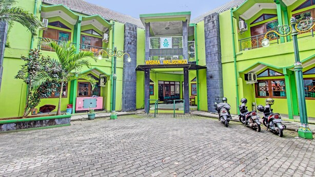 A building with a green facade and a sign reading "WISMA WALISONGO". - SPOT ON 91471 Syariah Wisma Uin Walisongo (Semarang)