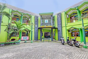 A building with a green facade and a sign reading "WISMA WALISONGO". - SPOT ON 91471 Syariah Wisma Uin Walisongo (Semarang)