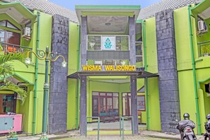 Un edificio con fachada verde y un cartel que dice 'WISMA WALISONGO'.