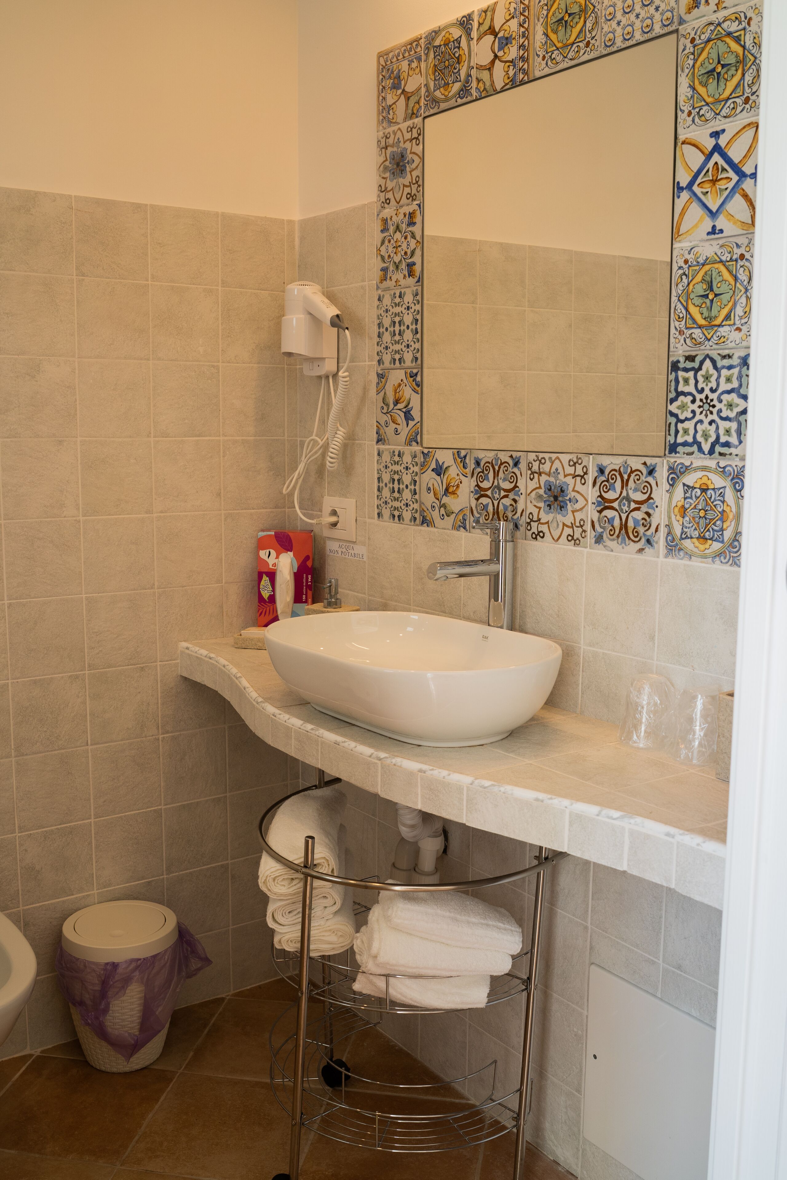 A bathroom with a white sink, a towel rack, and a toilet.