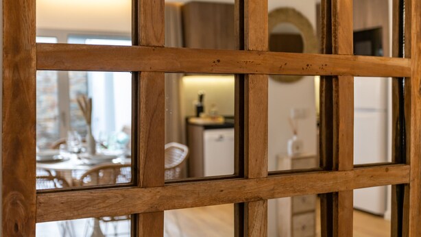 Un separador de ambientes de madera con diseño de celosía.