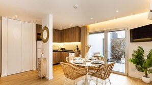 Un comedor moderno con una mesa redonda, sillas de mimbre y vistas al exterior.