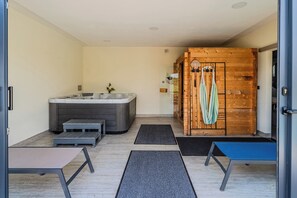 Une salle de bain moderne avec une baignoire, une douche et un mur en bois.