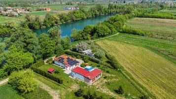 A rural property with a house, solar panels, and a swimming pool.