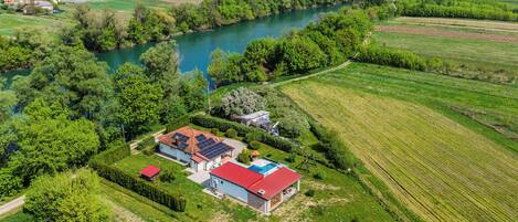 Een landelijk gelegen pand met een huis, zonnepanelen en een zwembad.