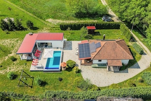 An aerial view of a property with a swimming pool, two houses, and solar panels. - Wellness House On The River Kupa (Karlovac)