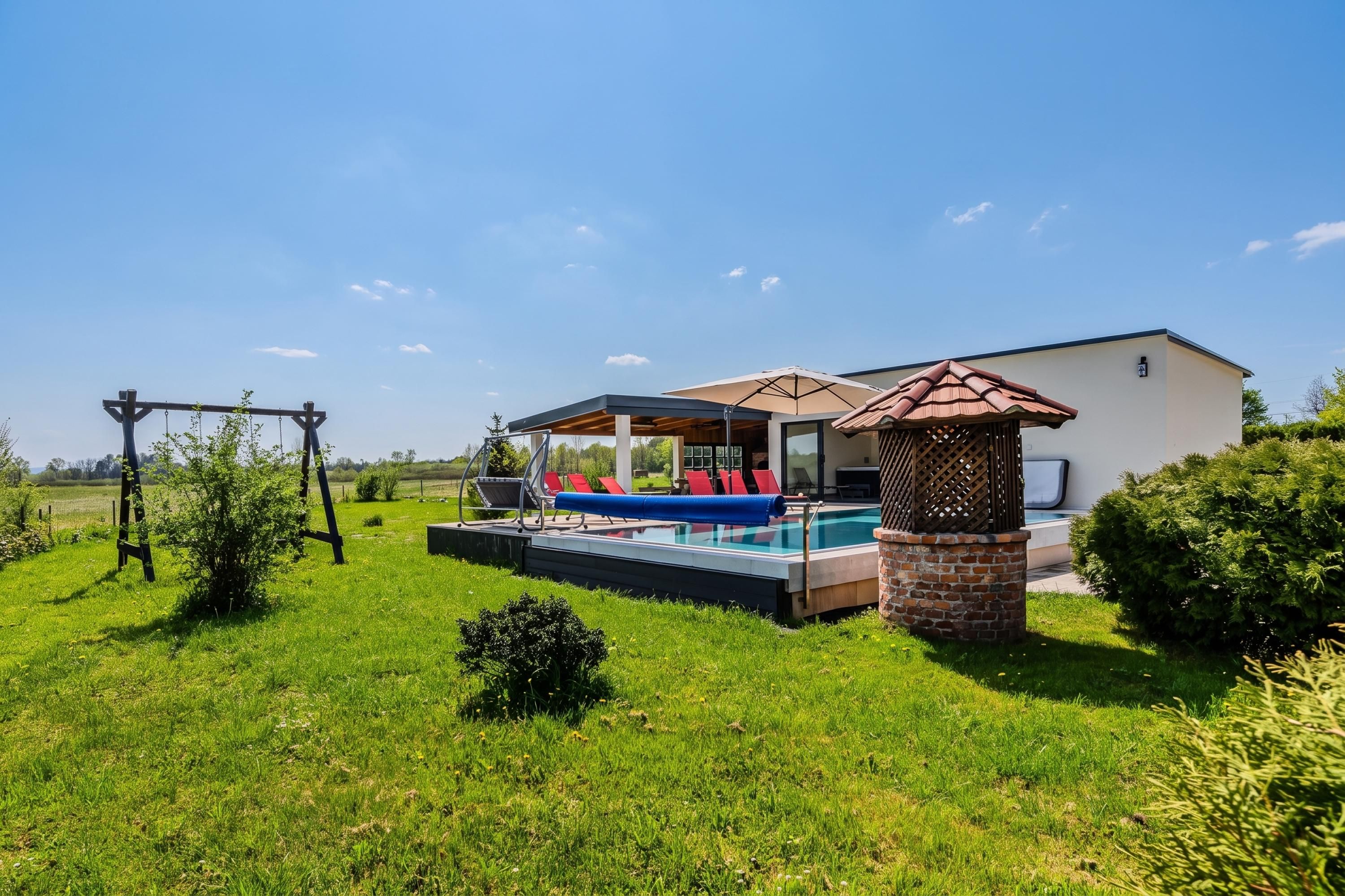 Una casa moderna con piscina, un patio con mobiliario exterior y un columpio.