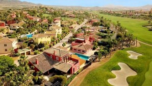 A residential area with houses, a swimming pool, and a golf course. - La Estrella 10, Desert Springs Golf Resort (Cuevas del Almanzora, Almería)