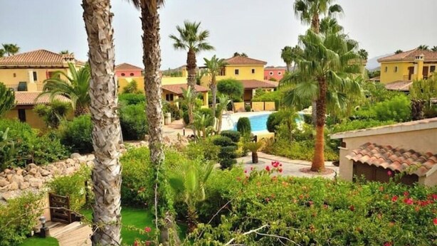 A residential area with multiple houses, a swimming pool, and lush greenery. - La Estrella 10, Desert Springs Golf Resort (Cuevas del Almanzora, Almería)