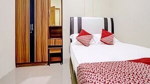A hotel room with a bed, a wardrobe with a mirror, and a red patterned bedspread. - Hotel O Suci Homestay SyariahNearKilas 7 TV (Batam)