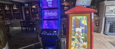 A checkered floor, a claw machine, and a slot machine with a bear illustration.