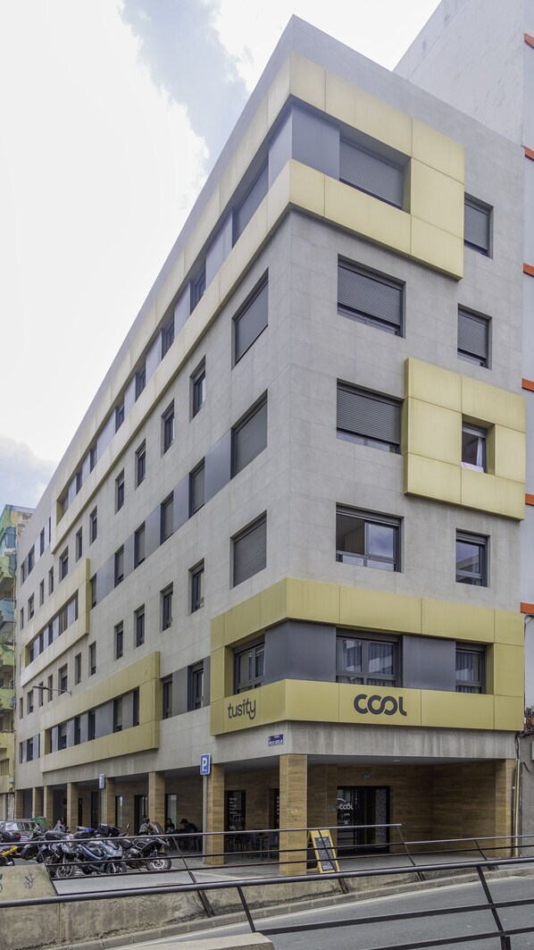 A multi-story building with a modern design, featuring a prominent 'Cool' sign on the ground floor, indicating a commercial space. - Tusity Yeah (Las Palmas de Gran Canaria)