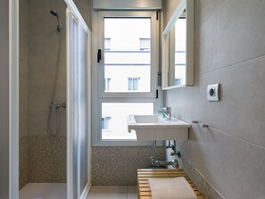 A modern bathroom with a shower, a sink, and a window. - Tusity Yeah (Las Palmas de Gran Canaria)