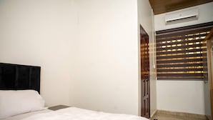 Une chambre à coucher comprenant un lit, une armoire et un appareil de climatisation.